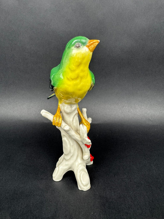 Figurine en porcelaine oiseau polychrome sur branche décor houx