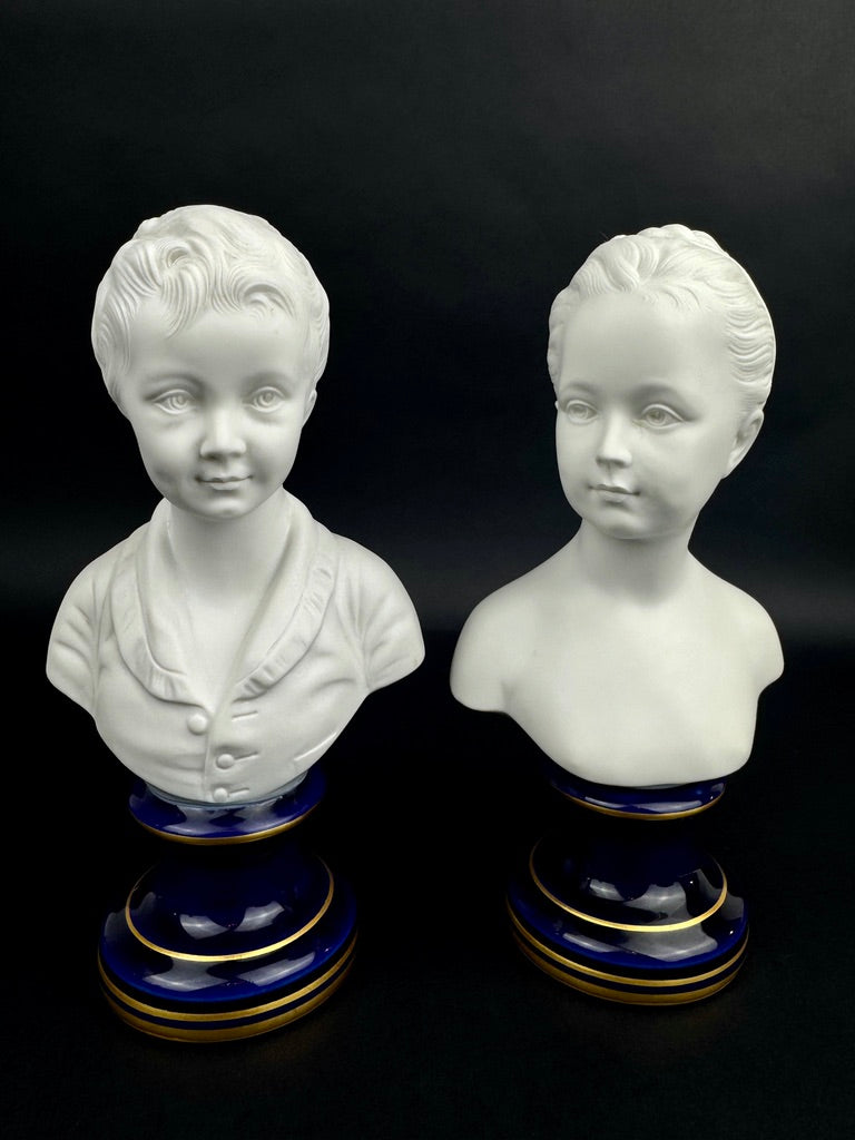 Paire de bustes Enfants Brongniart en biscuit de porcelaine de Limoges sur base bleu cobalt et or