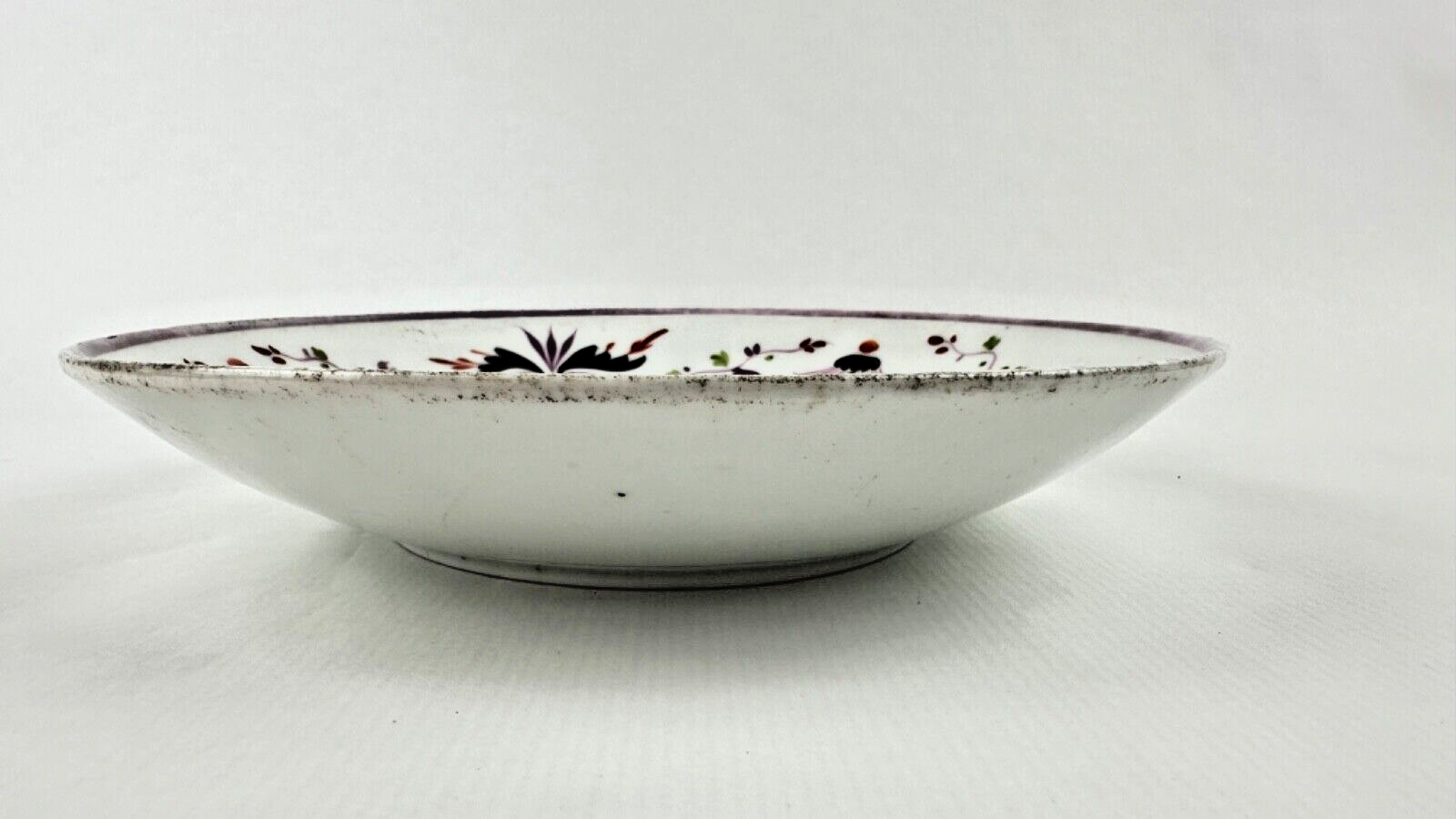 Deux assiettes époque restauration à rinceaux de fleurs mauves et noires