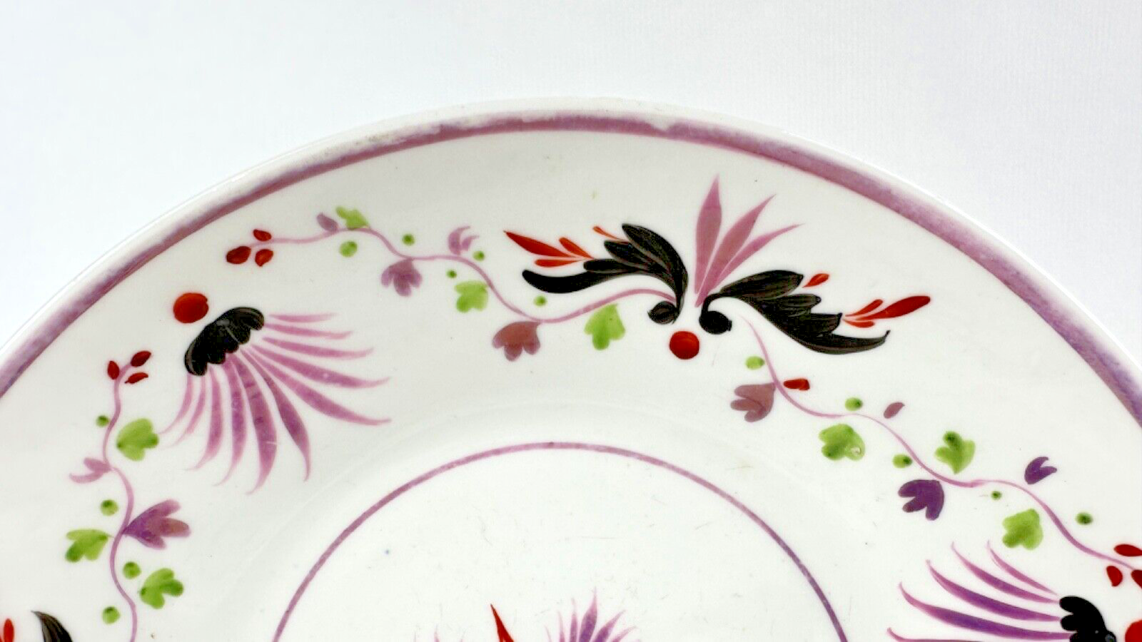Deux assiettes époque restauration à rinceaux de fleurs mauves et noires