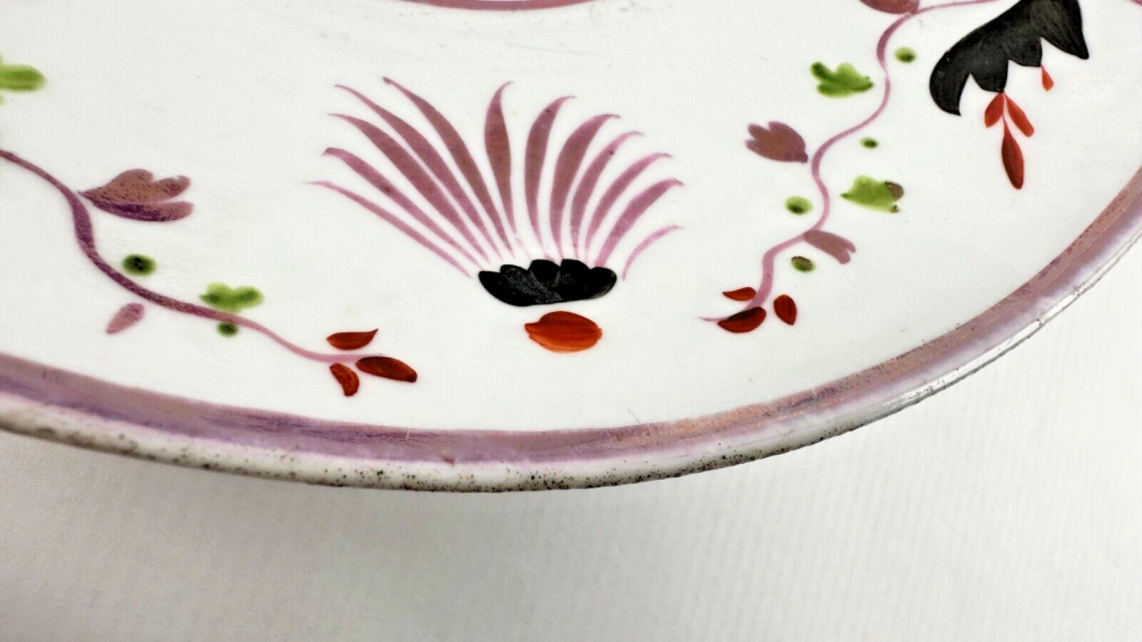 Deux assiettes époque restauration à rinceaux de fleurs mauves et noires