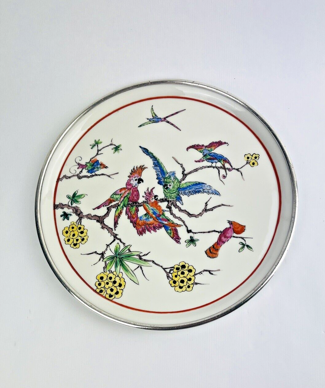 Ancien plat en porcelaine cerclé d'argent, décor de perroquets
