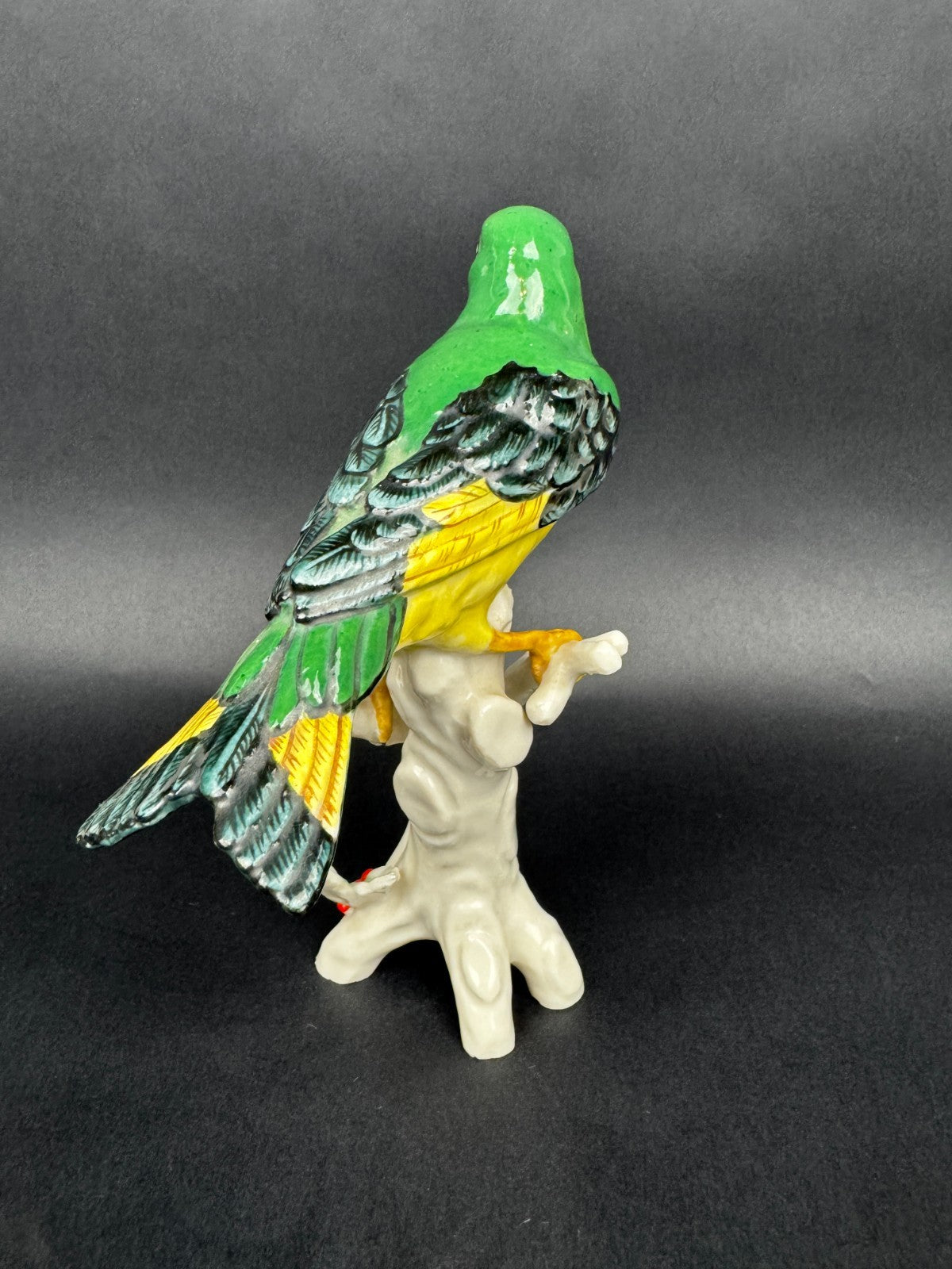 Figurine en porcelaine oiseau polychrome sur branche décor houx