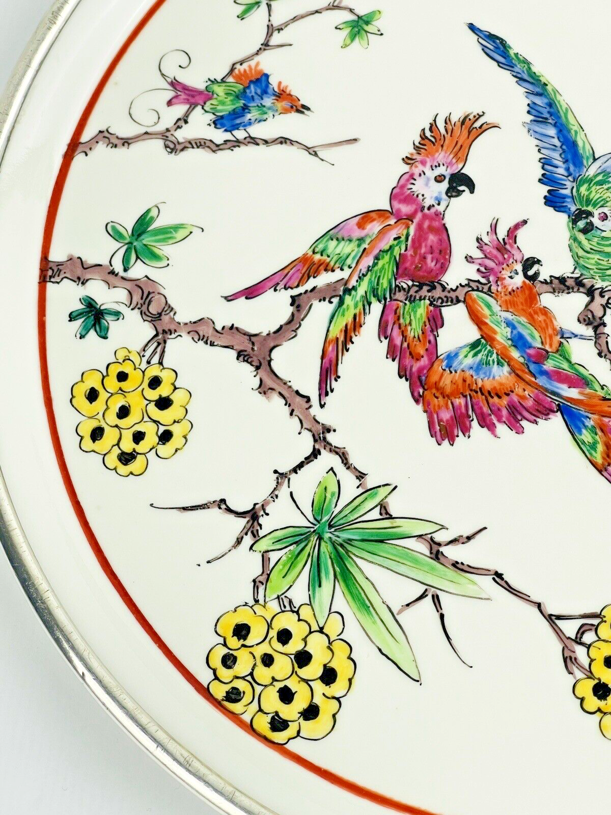 Ancien plat en porcelaine cerclé d'argent, décor de perroquets