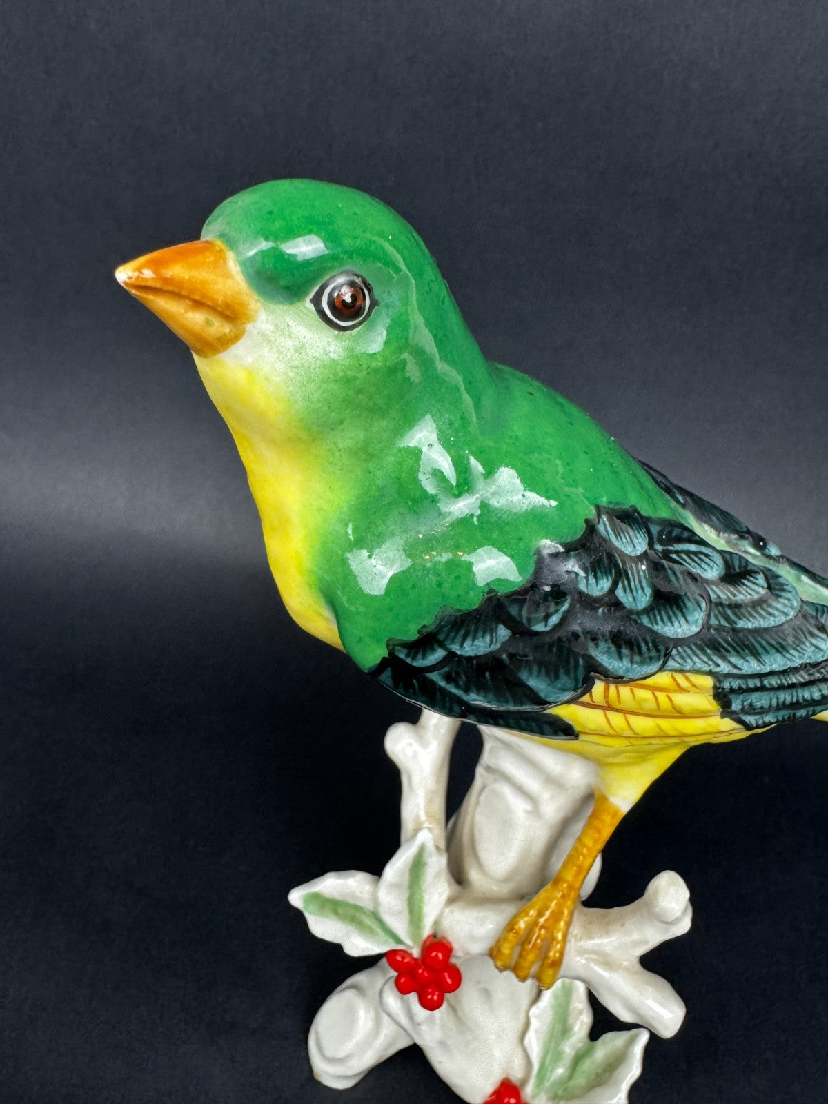 Figurine en porcelaine oiseau polychrome sur branche décor houx