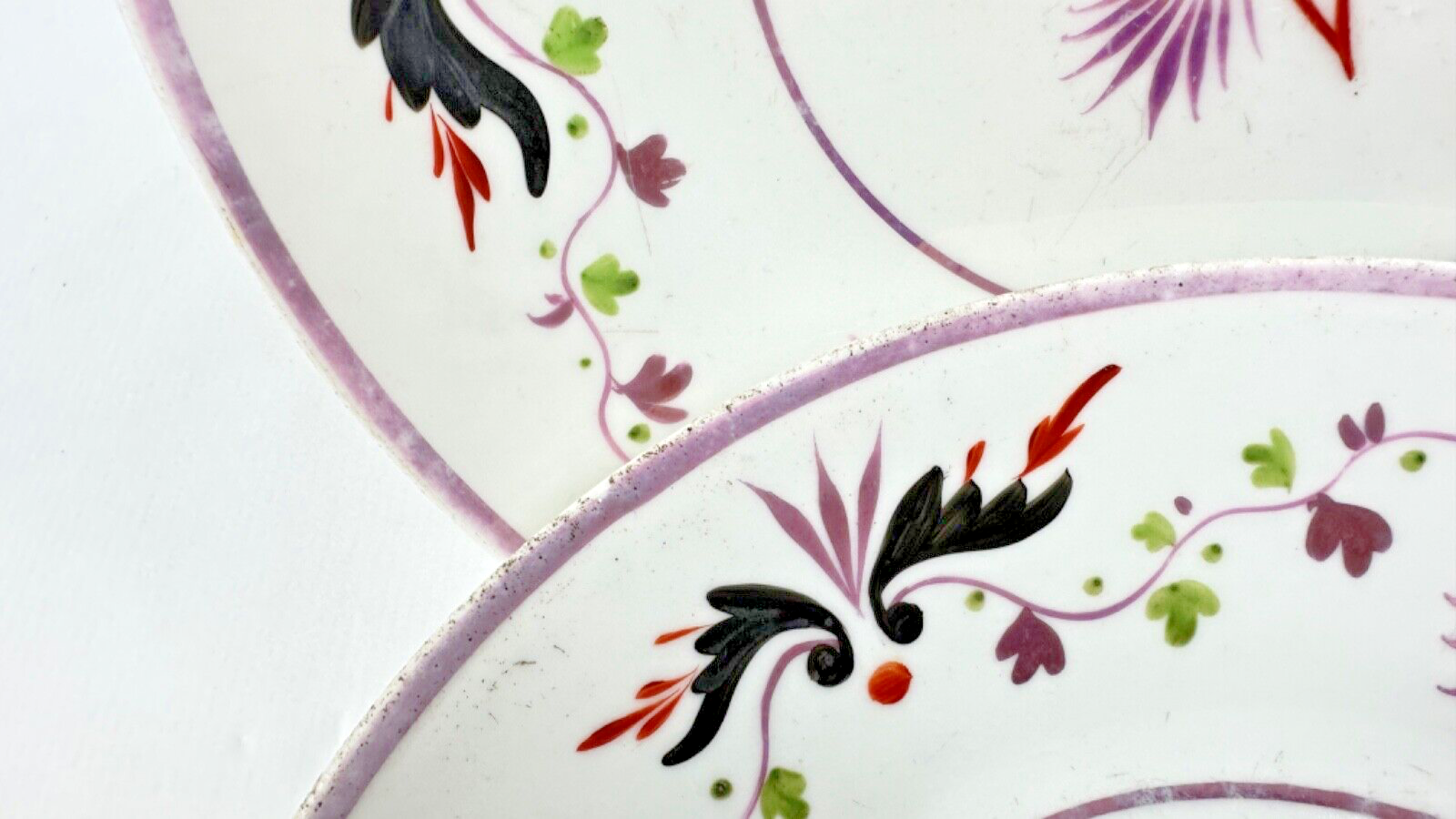 Deux assiettes époque restauration à rinceaux de fleurs mauves et noires