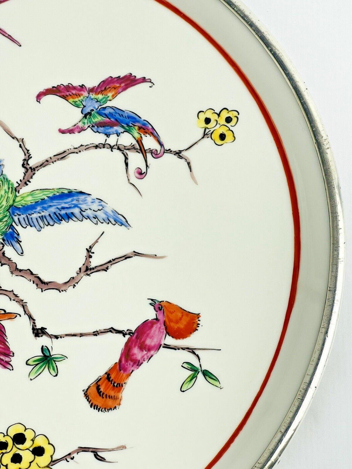 Ancien plat en porcelaine cerclé d'argent, décor de perroquets