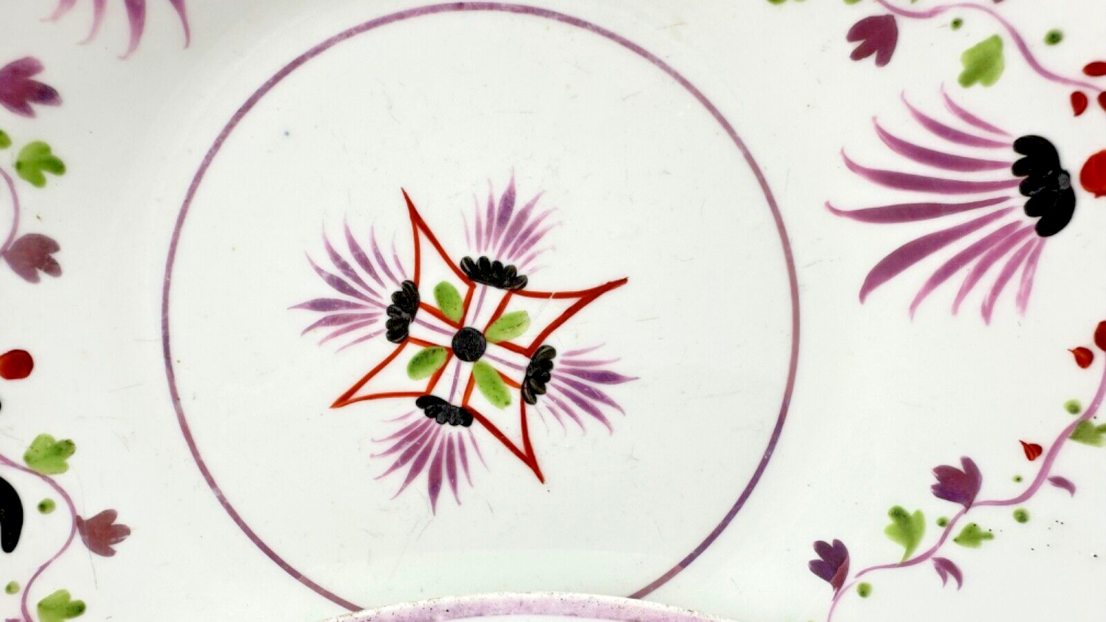 Deux assiettes époque restauration à rinceaux de fleurs mauves et noires
