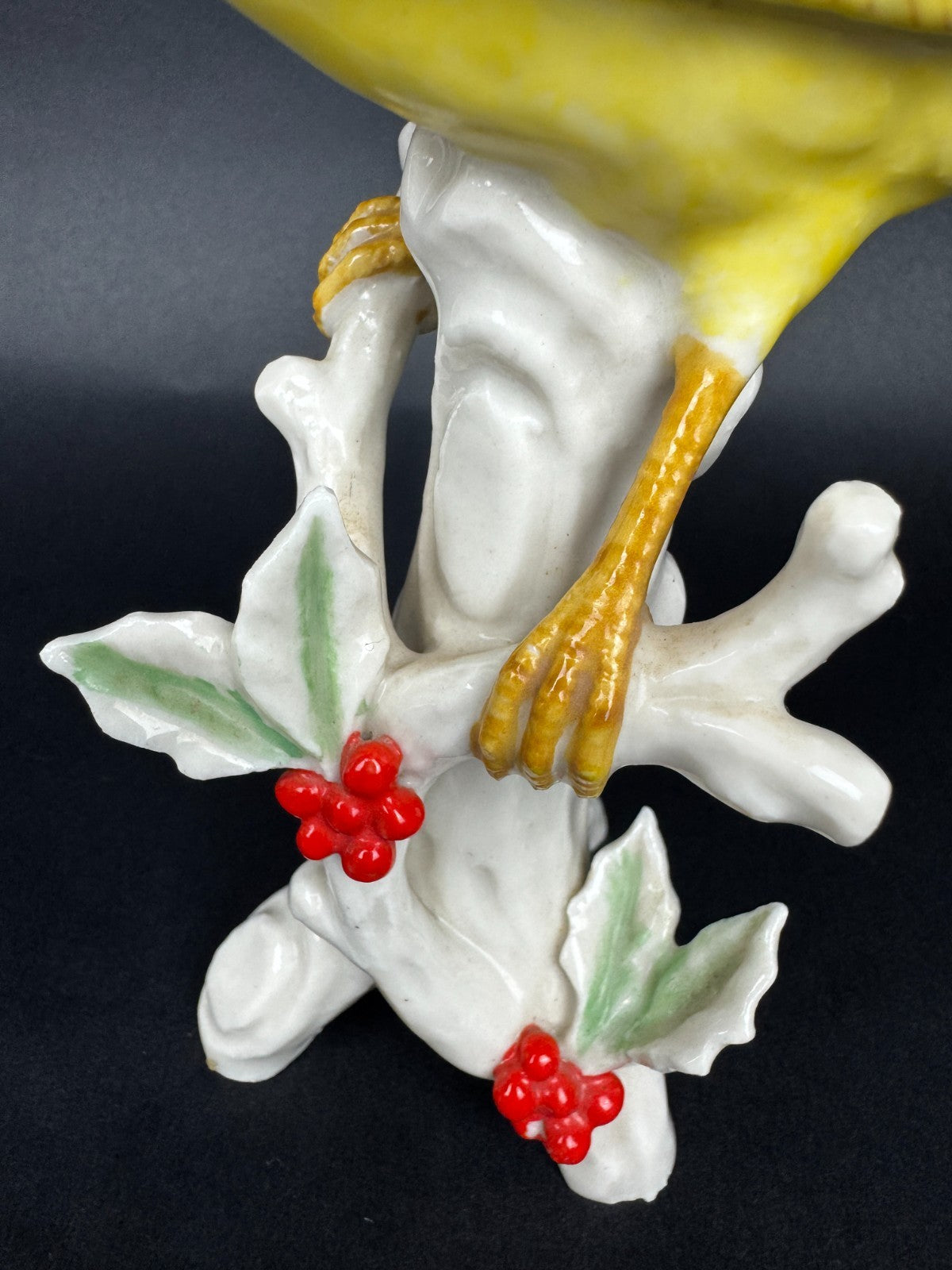 Figurine en porcelaine oiseau polychrome sur branche décor houx