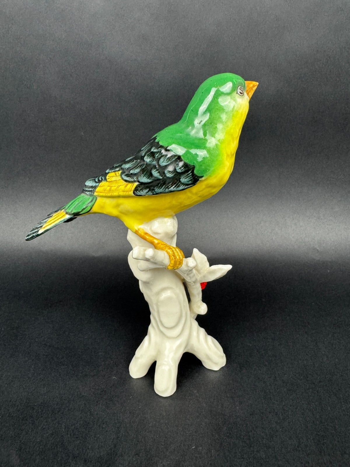 Figurine en porcelaine oiseau polychrome sur branche décor houx