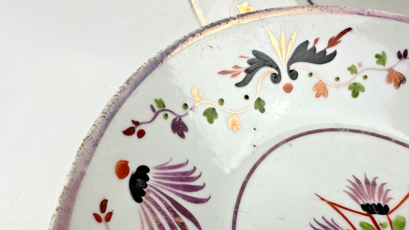 Deux assiettes époque restauration à rinceaux de fleurs mauves et noires